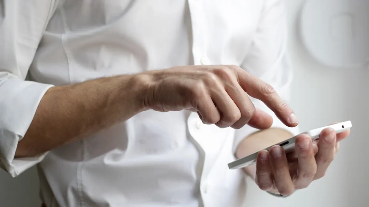 Hånd som holder en mobiltelefon