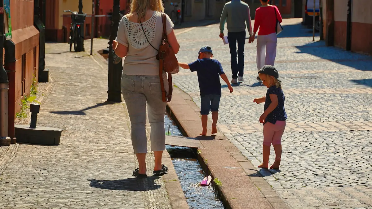 Familie som går nedover en brolagt gate langs en kanal