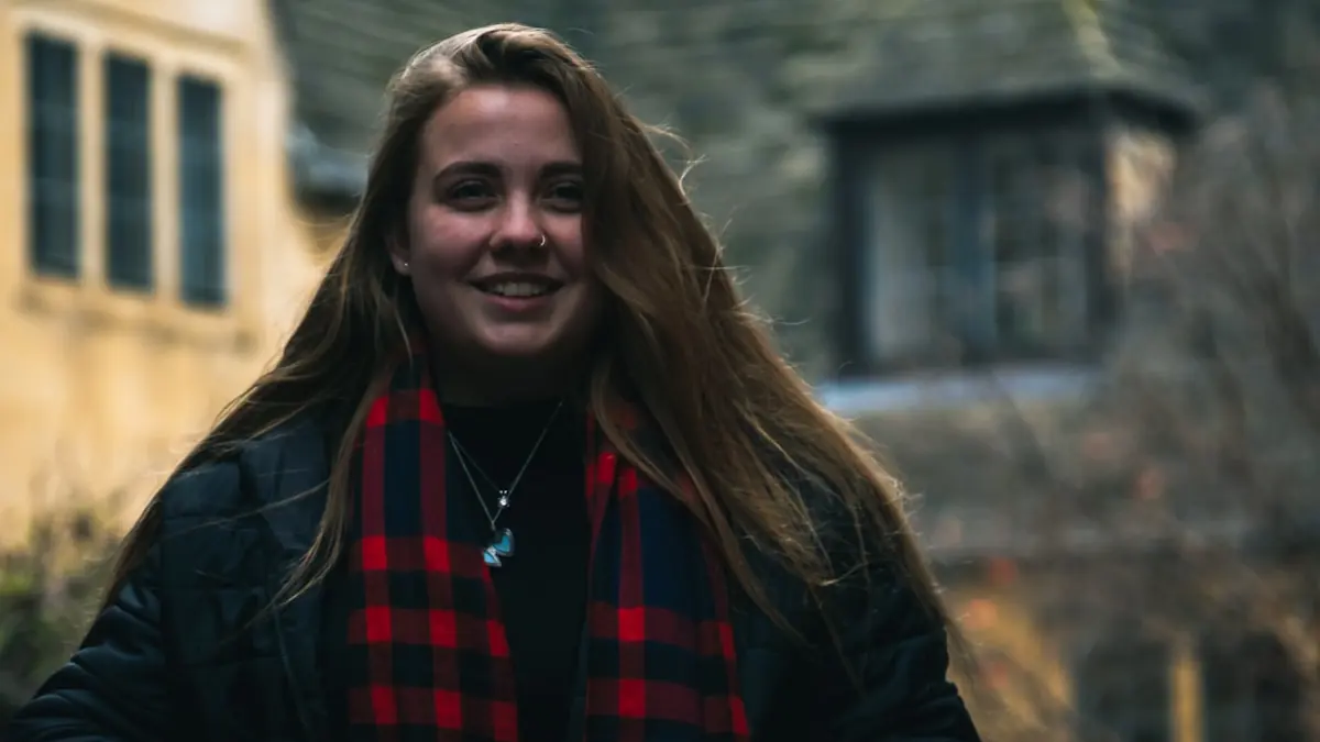 Ung kvinne som smiler utendørs